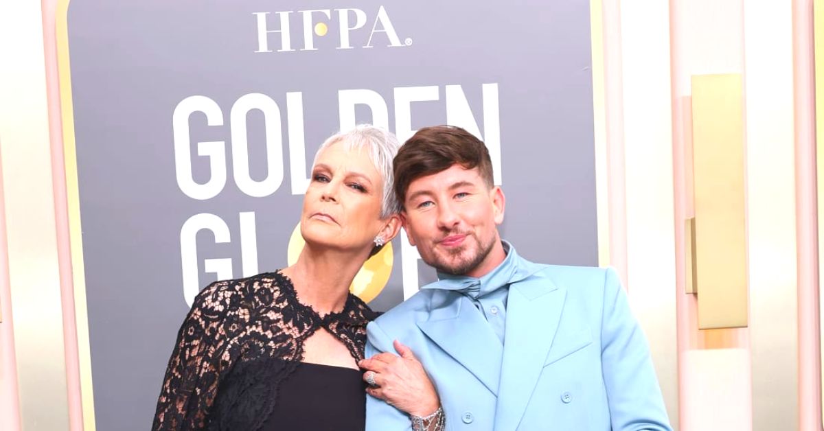 Jamie Lee Curtis, who wore a lace cape over her strapless Valentino jumpsuit, poses with The Banshees of Inisherin star Barry Keoghan in a double-breasted powder blue suit by Louis Vuitton