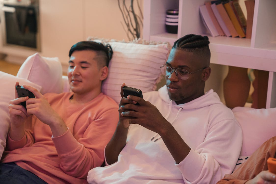 Free Men Sitting on the Couch Using Their Phones Stock Photo