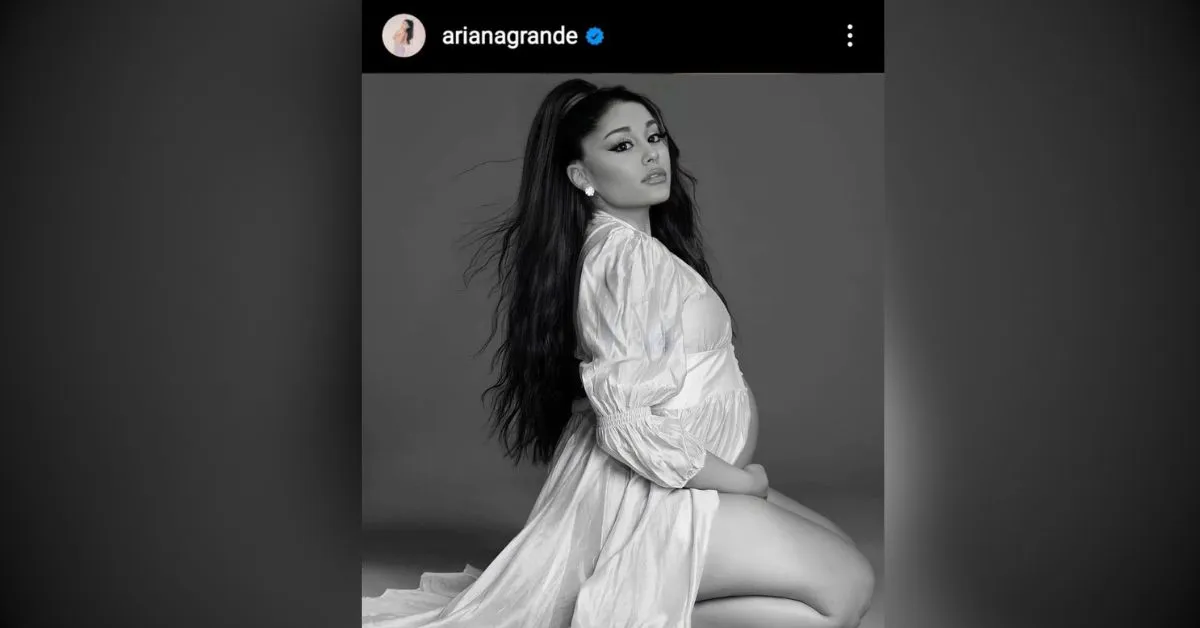Ariana Grande sitting in a white dress with her edited baby bump